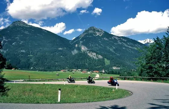 Motorräder in einer Kurve im Namloser Tal vor Bergkulisse